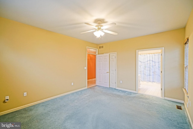 unfurnished bedroom with carpet, ceiling fan, and ensuite bath