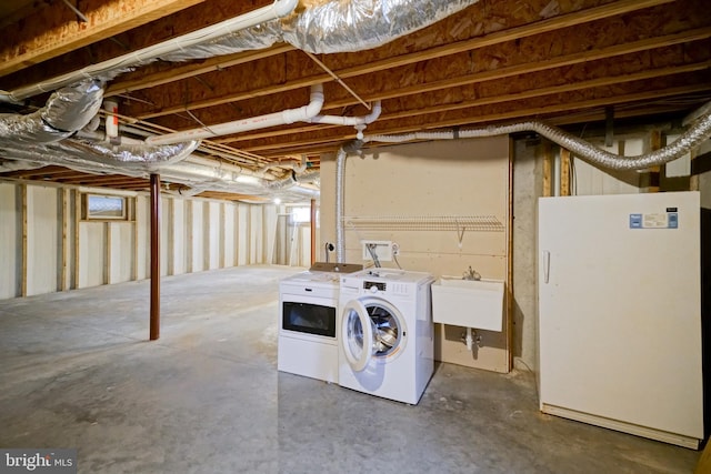 basement with separate washer and dryer, sink, and white refrigerator