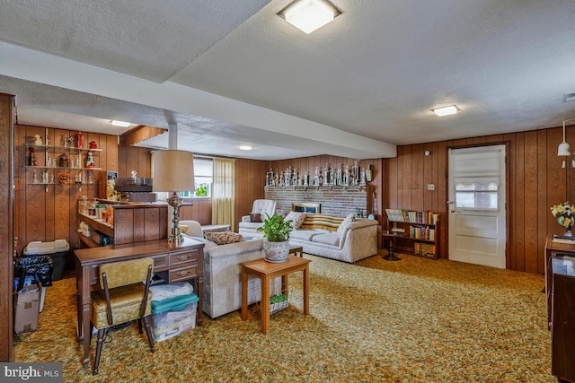 carpeted living room with wooden walls, a fireplace, and a textured ceiling