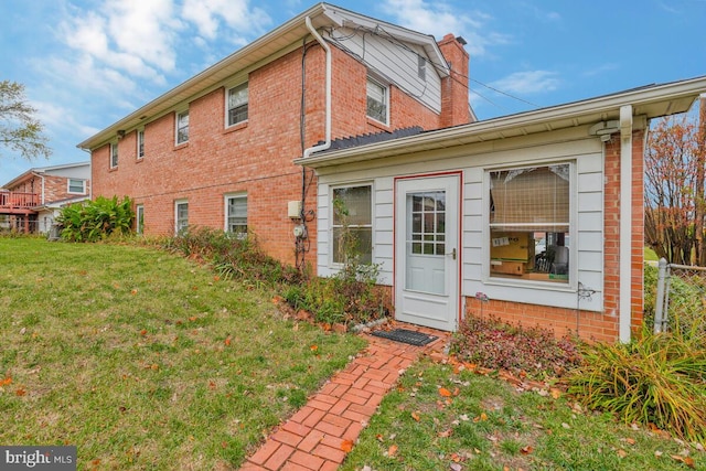 rear view of property featuring a lawn