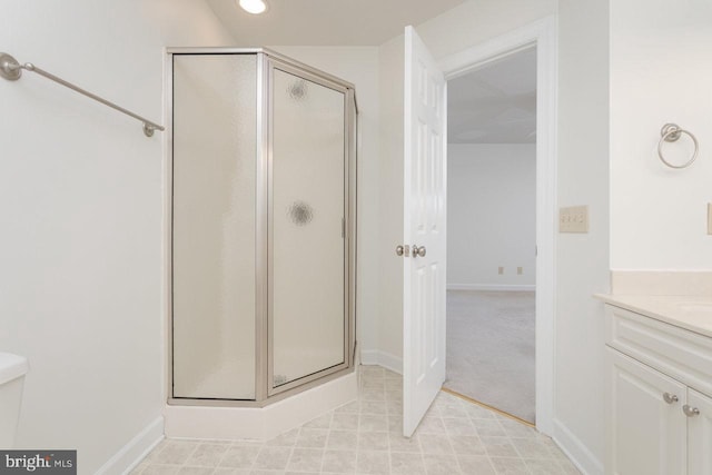 bathroom featuring a shower with door and vanity