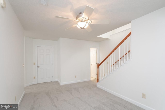 carpeted spare room with ceiling fan and a textured ceiling