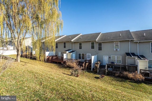 back of house featuring a lawn and a wooden deck