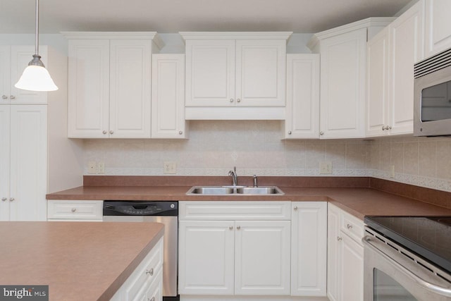 kitchen featuring white cabinetry, sink, decorative light fixtures, decorative backsplash, and appliances with stainless steel finishes