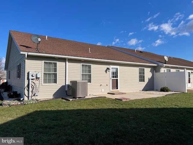 back of house featuring a lawn, a patio area, and central AC