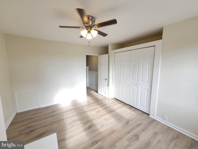 unfurnished bedroom with a closet, light hardwood / wood-style flooring, and ceiling fan