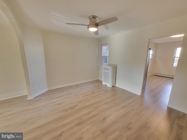 interior space featuring baseboard heating, ceiling fan, and light hardwood / wood-style floors