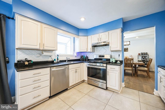 kitchen featuring backsplash, sink, light tile patterned flooring, and stainless steel appliances