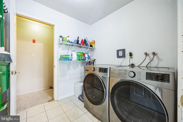 clothes washing area with light tile patterned flooring and washer and dryer