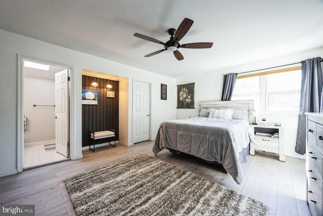 bedroom featuring ensuite bathroom, light hardwood / wood-style flooring, and ceiling fan