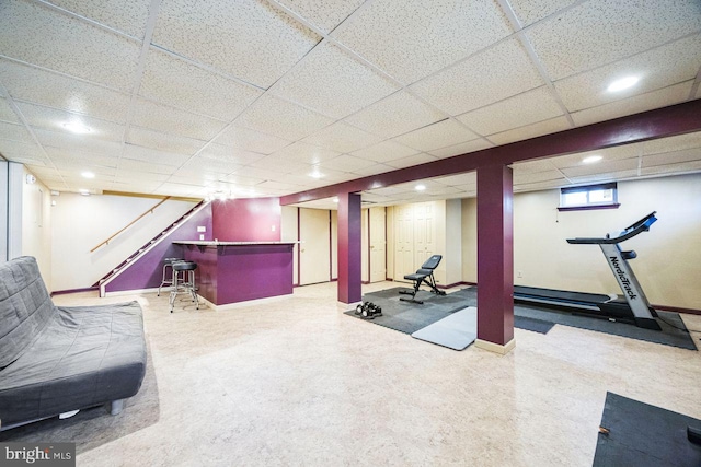 exercise room featuring a paneled ceiling and indoor bar