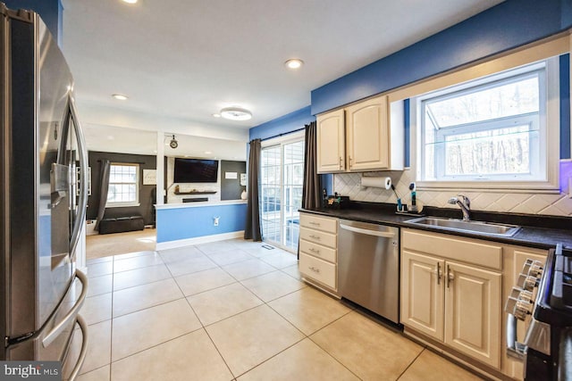 kitchen with backsplash, light tile patterned floors, sink, and appliances with stainless steel finishes