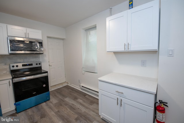 kitchen with appliances with stainless steel finishes, a baseboard radiator, white cabinetry, and dark wood-type flooring