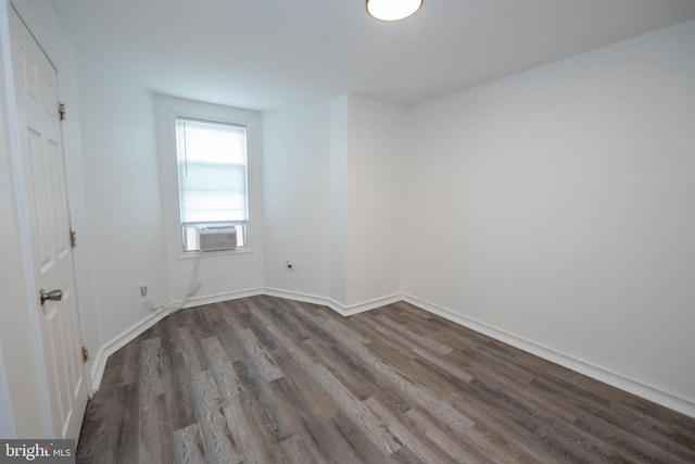 spare room with cooling unit and dark hardwood / wood-style floors