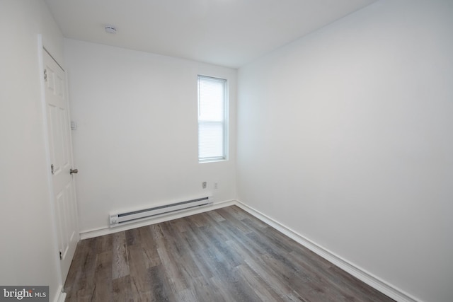 spare room with dark hardwood / wood-style flooring and a baseboard radiator