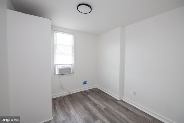 spare room with cooling unit and wood-type flooring