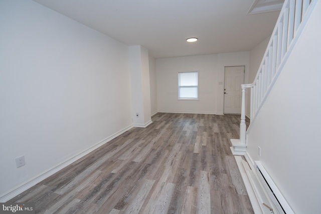 unfurnished living room with a baseboard radiator and light hardwood / wood-style flooring