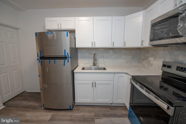 kitchen featuring white cabinetry, sink, stainless steel appliances, dark hardwood / wood-style flooring, and decorative backsplash