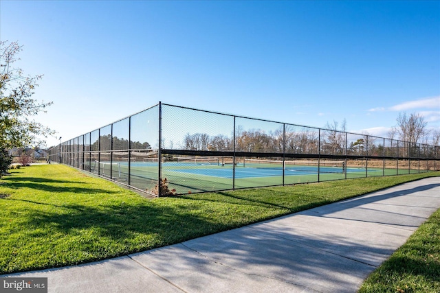 view of sport court with a lawn