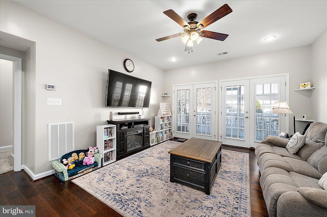 living room with french doors, ceiling fan, and dark wood-type flooring