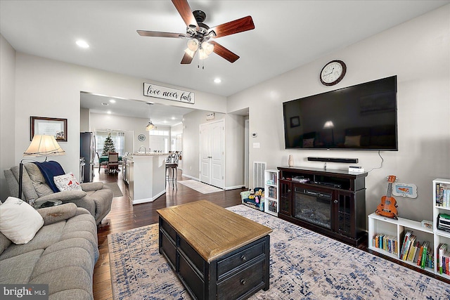 living room with dark hardwood / wood-style floors and ceiling fan