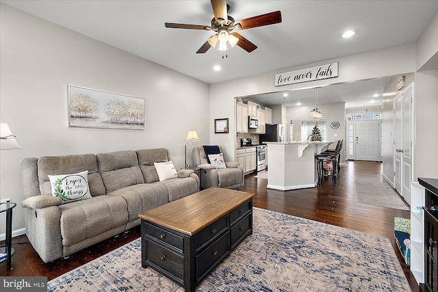 living room with dark hardwood / wood-style floors and ceiling fan