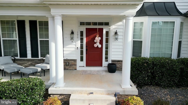 view of exterior entry featuring covered porch