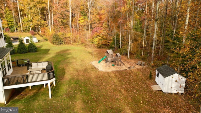 view of yard with a playground, a shed, and a deck