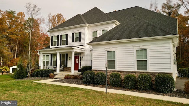 view of property featuring a porch and a front lawn