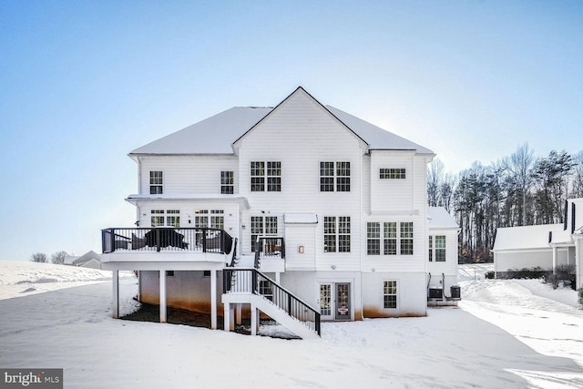 snow covered property featuring cooling unit and a deck