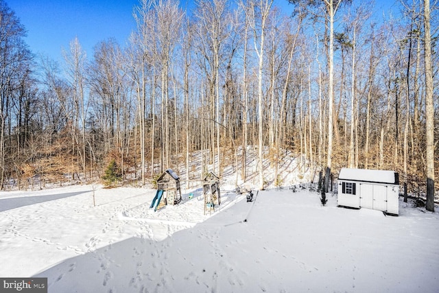 yard covered in snow with a storage shed