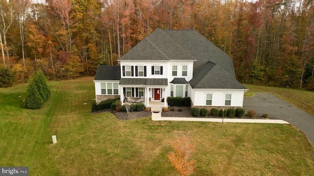 colonial inspired home with a porch and a front yard