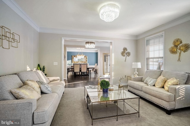 living room with wood-type flooring, crown molding, and an inviting chandelier