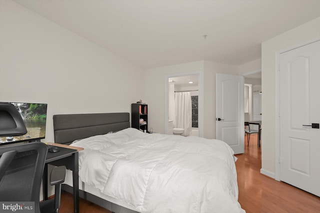 bedroom featuring hardwood / wood-style flooring and ensuite bath