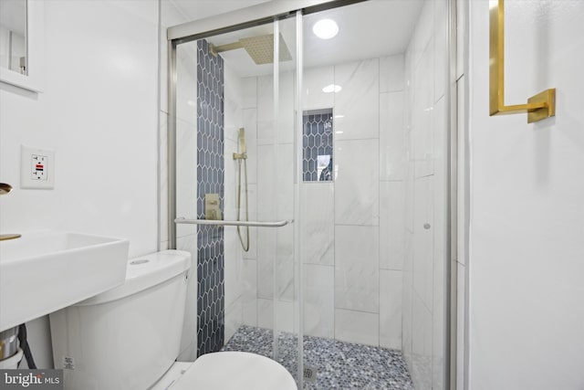 bathroom featuring toilet and a shower with shower door