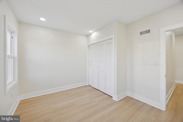 unfurnished bedroom featuring light hardwood / wood-style flooring and a closet