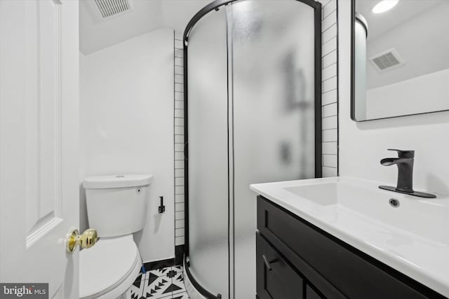 bathroom with vanity, toilet, and a shower with door