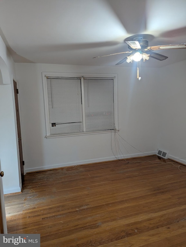 empty room featuring ceiling fan and dark wood-type flooring