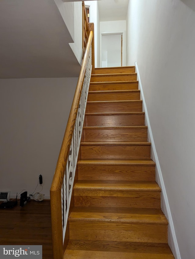 staircase with hardwood / wood-style floors