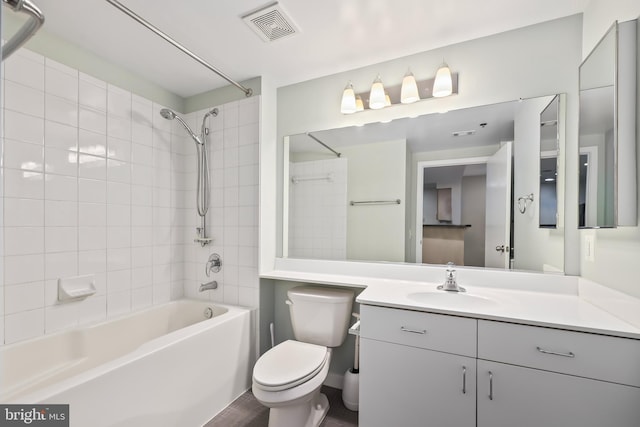 full bathroom featuring toilet, vanity, and tiled shower / bath