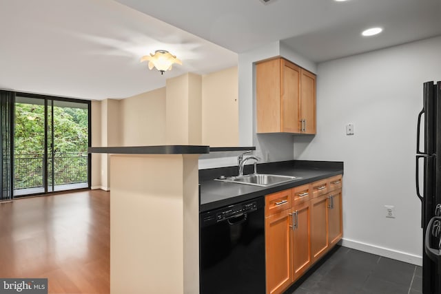 kitchen with black appliances, expansive windows, sink, dark hardwood / wood-style flooring, and kitchen peninsula