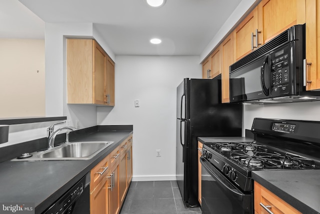 kitchen featuring sink, dark tile patterned floors, and black appliances