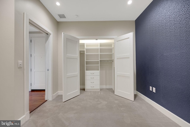 unfurnished bedroom with light colored carpet and a closet