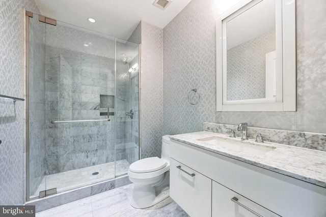 bathroom featuring vanity, toilet, and a shower with door