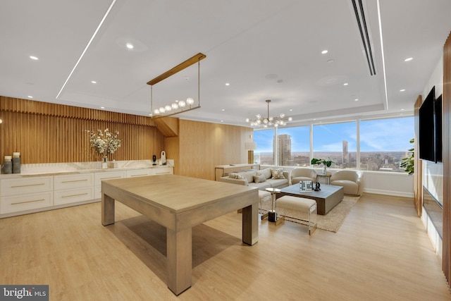 interior space featuring a chandelier, light hardwood / wood-style floors, and wood walls