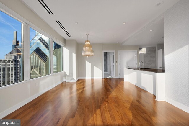 50 S 16th St Unit 5102, Philadelphia, PA 19102 - unfurnished living room with a chandelier, wood finished floors, a sink, and baseboards