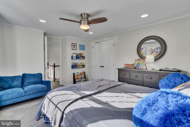 carpeted bedroom with a closet, ceiling fan, and crown molding