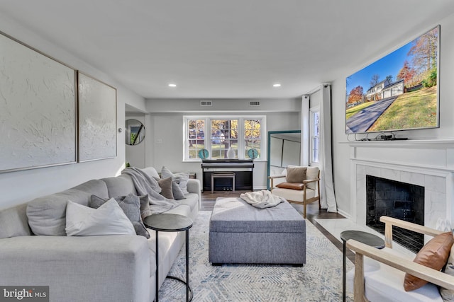 living room featuring a tile fireplace and light hardwood / wood-style flooring