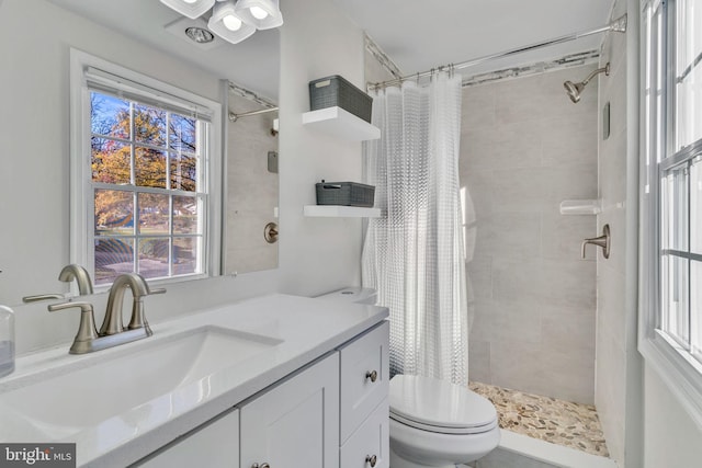 bathroom with vanity, walk in shower, and a healthy amount of sunlight