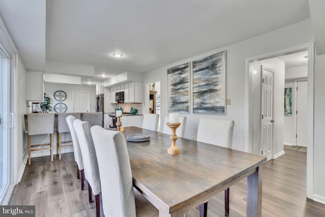 dining area with light hardwood / wood-style floors and a wealth of natural light